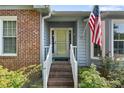 Close-up of a front door with brick steps, white railings, and an American flag at 73 Night Heron Ct, Sanford, NC 27332