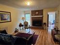 Cozy living room featuring a brick fireplace, hardwood floors, and comfortable seating, perfect for relaxation at 73 Night Heron Ct, Sanford, NC 27332