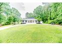 Expansive front yard view of a well-maintained home, surrounded by lush greenery at 220 Topside, Sanford, NC 27332