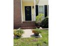 Inviting front porch with beautiful flower pots flanking the entrance at 284 Coachman Way, Sanford, NC 27332