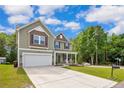 Inviting home exterior with a long driveway and well-kept lawn, nestled near lush trees at 296 Birch Ave, Spring Lake, NC 28390