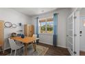 Bright dining room features a large window with blue curtains and modern furnishings at 665 Wilder Bloom Path, Aberdeen, NC 27526