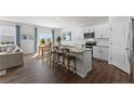 Open-concept kitchen with an island, breakfast bar, white cabinets, and stainless steel appliances at 665 Wilder Bloom Path, Aberdeen, NC 27526