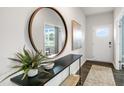 Home's entryway features a round mirror, decor, and a view to the outside at 668 Wilder Bloom Path, Aberdeen, NC 27526