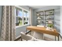 Bright home office features a large window, modern desk, and stylish decor at 668 Wilder Bloom Path, Aberdeen, NC 27526