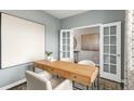 Home office boasts modern desk, white chairs, and a doorway to an adjacent room at 668 Wilder Bloom Path, Aberdeen, NC 27526