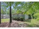 Side view of a house with lush greenery, highlighting the property's natural surroundings and private setting at 95 Fairway Ln, Sanford, NC 27332