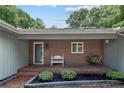 Inviting front porch with brickwork, seating, and potted plants, creating a welcoming entrance to the home at 95 Fairway Ln, Sanford, NC 27332