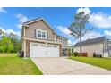 Exterior view of a two-story home with a two-car garage and a well-maintained yard at 104 Parkview Ln, Lillington, NC 27546