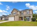 Beautiful front yard view of a two story home with a two car garage, well maintained lawn, and inviting front porch at 104 Parkview Ln, Lillington, NC 27546