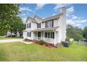 Beautiful two-story home featuring a front porch with black shutters, complemented by a well-manicured lawn at 186 Yorkshire Dr, Cameron, NC 28326