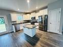 Stylish kitchen features stainless steel appliances, white cabinets, kitchen island and a door leading outside at 4179 Overhills Rd, Spring Lake, NC 28390