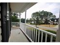 Covered front porch with white railings, perfect for relaxing and enjoying the neighborhood views at 70 Ramsey Ct, Cameron, NC 28326