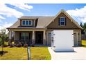 Charming home featuring a well-manicured lawn, inviting front porch, and attached garage at 70 Waxflower Dr, Smithfield, NC 27577