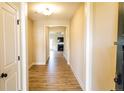 Inviting hallway with gleaming wood floors leading to an open living area with fireplace at 70 Waxflower Dr, Smithfield, NC 27577