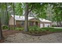 Single story brick home with a two-car garage and ample trees on the property at 129 Silver Lake Pt, Sanford, NC 27332