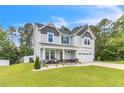 Inviting two-story home with a covered front porch, manicured lawn, and attached two-car garage at 186 Old Glory Ln, Cameron, NC 28326