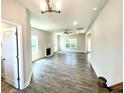 An open-concept living room with a fireplace, large windows, and light gray walls, filled with natural light at 193 Falls Of The Cape Dr, Lillington, NC 27546