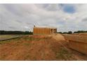 View of partially constructed home with exterior walls under construction with worker on top at 214 Uwharrie Way, Sanford, NC 27330