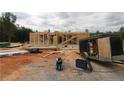 View of a construction site with partially framed house and trailer with workers on the frame at 214 Uwharrie Way, Sanford, NC 27330