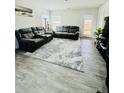 Spacious living room with grey sofas, plush rug, and light-filled atmosphere, ideal for relaxation at 3202 Finch Ct, Sanford, NC 27332