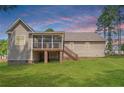 View of backyard featuring a screened-in porch with stairs leading to the ground at 16 Quail Holw, Sanford, NC 27332