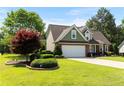 Well-maintained two-story home with lush lawn, manicured landscaping, brick details, attached garage, and inviting curb appeal at 626 Orchard Falls Dr, Spring Lake, NC 28390