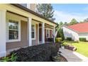 Inviting front porch showcasing decorative columns, manicured landscaping, and a glimpse of the home's exterior at 626 Orchard Falls Dr, Spring Lake, NC 28390