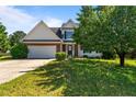 Welcoming two-story house with a brick-detailed front, attached garage, and a lush green lawn with mature foliage at 81 Checkmate Ct, Cameron, NC 28326