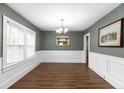 Dining room with wainscoting, dark green walls, chandelier and wood flooring at 1001 N Orange Ave, Dunn, NC 28334