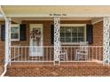 Close-up of the front porch with decorative columns and seating at 209 4Th St, Erwin, NC 28339