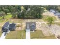 Aerial view of a gray two-story home with a long driveway, fenced yard, and surrounding greenery at 225 Persimmon Tree Dr, Cameron, NC 28326