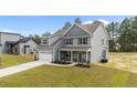 Beautiful two-story home featuring gray siding, a manicured lawn, and a two-car garage in a suburban setting at 225 Persimmon Tree Dr, Cameron, NC 28326