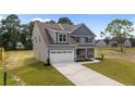 Attractive two-story home with gray siding, a two-car garage, and a well-maintained lawn at 225 Persimmon Tree Dr, Cameron, NC 28326