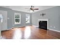 Bright living room features a fireplace, ceiling fan, and beautiful hardwood floors at 31 Boston Hbr, Cameron, NC 28326