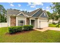 Attractive home featuring stone accents, manicured landscaping, and a two-car garage at 49 Infantry Dr, Cameron, NC 28326