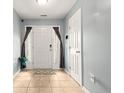 Welcoming foyer with neutral tile flooring, coat closet, and ample natural light at 49 Infantry Dr, Cameron, NC 28326