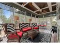 Inviting screened porch with comfortable wicker furniture, decorative rugs, and a ceiling fan at 60 Rolling Pines Dr, Spring Lake, NC 28390