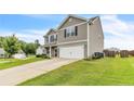 Side view of a two-story home featuring gray siding, a well-kept lawn and a two-car garage at 641 Avery Pond Dr, Fuquay Varina, NC 27526