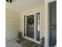 Close up of front door with a wreath, decorative glass, a patterned rug and a small lantern at 99 Riviera Ln, Sanford, NC 27332