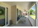 Inviting covered porch with wicker seating, ceiling fan, lanterns and charming trim at 99 Riviera Ln, Sanford, NC 27332