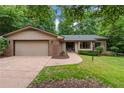 Single-story home featuring an attached two-car garage, brick accents, and a meticulously kept front lawn at 2024 Sandalwood Dr, Sanford, NC 27332