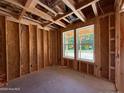 Unfinished bedroom showcasing stud framing, electrical outlets, and natural light through the windows at 209 Atkins Rd, Cameron, NC 28326