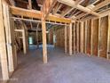 Unfinished living room showcasing the stud framing, open layout, and natural light streaming in through the door at 209 Atkins Rd, Cameron, NC 28326
