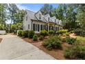 Beautifully landscaped home featuring a metal roof, white siding and black shutters at 2190 Keith Hills Rd, Lillington, NC 27546
