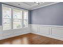 Elegant dining room with wainscoting, hardwood floors, and large windows at 252 School Side Dr, Spring Lake, NC 28390