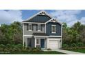Charming two-story home featuring a blue and gray color scheme, a garage, and a landscaped front yard at 29 Horse Trot Ln, Sanford, NC 27332