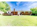 Expansive backyard with a brick home featuring a wooden deck, fire pit and expansive lawn at 2911 Wicker St, Sanford, NC 27330