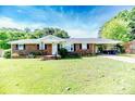 Inviting single-story brick home with a lush green lawn and attached carport for convenient parking at 2911 Wicker St, Sanford, NC 27330