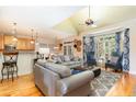 Bright, open living room featuring hardwood floors, modern furnishings, and a sunlit bay window at 4012 Sorrell Brothers Ct, Raleigh, NC